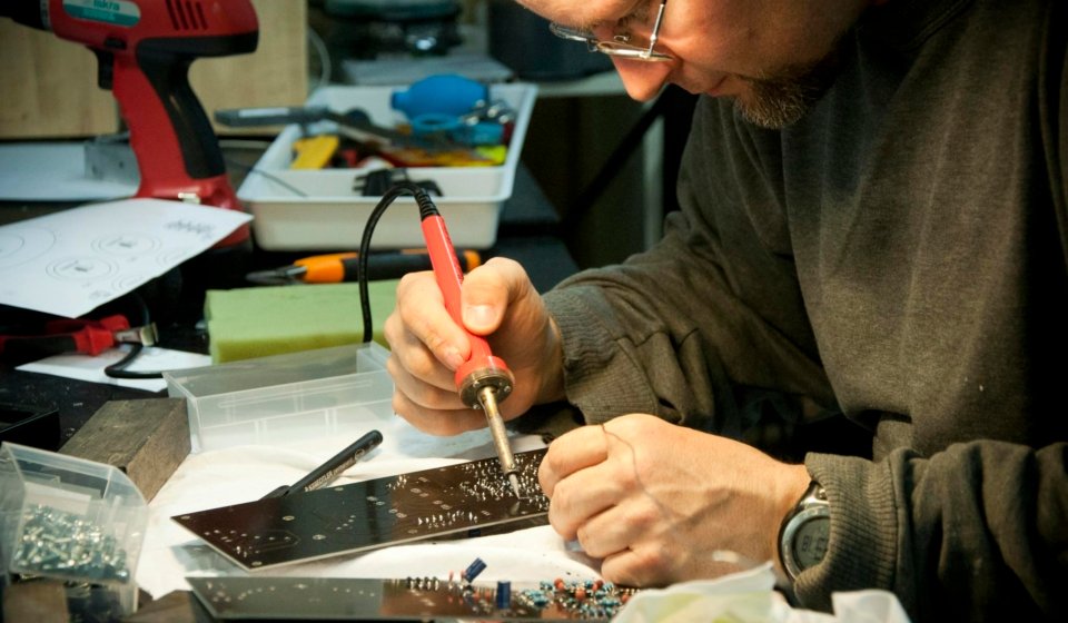 Man Soldering Circuit Board