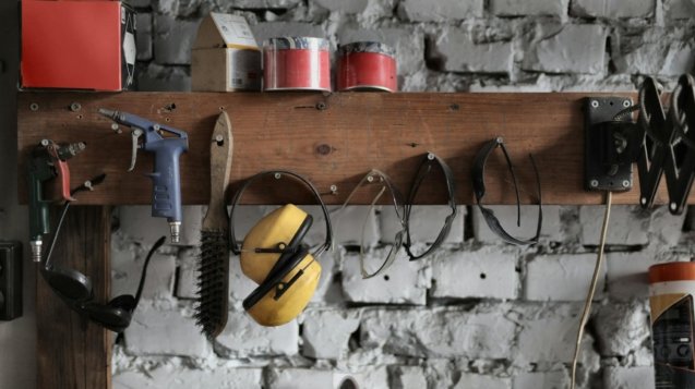 Various instruments hanging on wooden board in garage